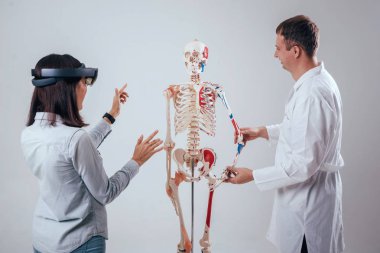 Doktor kullanır augmented gerçeklik gözlükleri ve öğrenci öğretim insan iskeleti