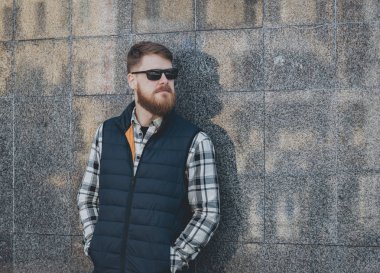 Yakışıklı adam açık havada kameraya poz rahat kıyafetler içinde sakallı