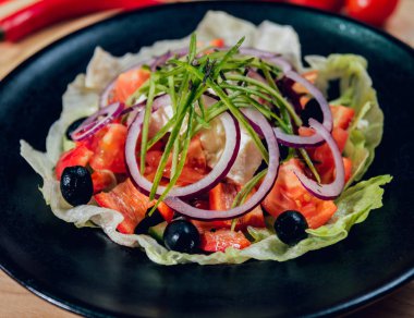 Lahana, zeytin ve mozzarella peyniri siyah plaka üzerinde Yunan salatası