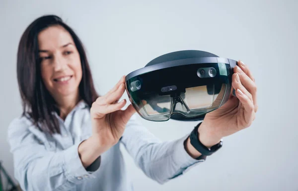 Woman wearing augmented reality goggles, isolated on white