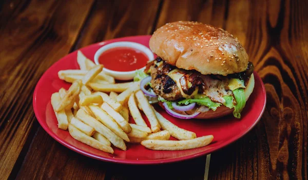 Big cheeseburger and chips on a plate. Restaurant