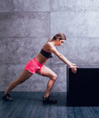 Studio poz ve farklı egzersizleri yapıyor genç atletik beyaz kadın.