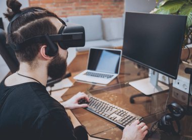 Sanal gerçeklik giyen sakallı genç adam ofiste gözlükler