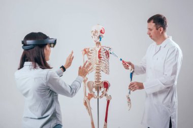 Doktor kullanır augmented gerçeklik gözlükleri ve öğrenci öğretim insan iskeleti