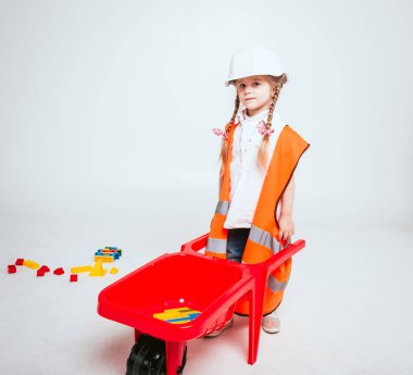 Onarım veya inşaat oynarken örgüler ile küçük neşeli kız