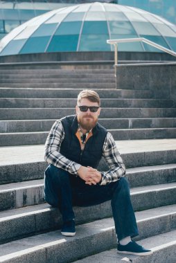 Kameraya poz rahat kıyafetler içinde sakallı yakışıklı.