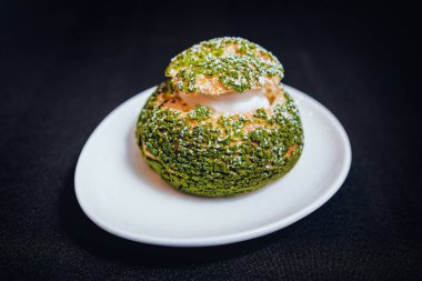 Wihte plaka siyah yüzeyi üzerinde yeşil profiterol