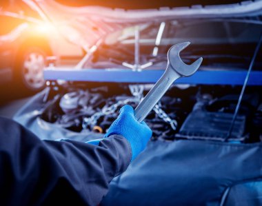 Erkek el motoru servis istasyonu tamiri için aracı tutarak