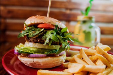 Büyük çizburger ve patates kızartması bir plaka üzerinde. Restoran