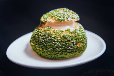 Wihte plaka siyah yüzeyi üzerinde yeşil profiterol