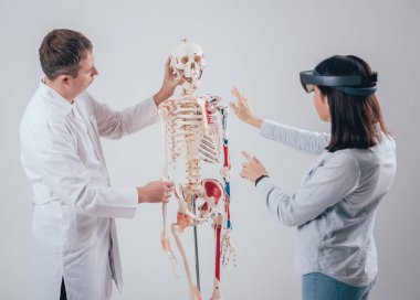 Doktor kullanır augmented gerçeklik gözlükleri ve öğrenci öğretim insan iskeleti