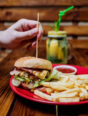 Büyük çizburger ve patates kızartması bir plaka üzerinde. Restoran