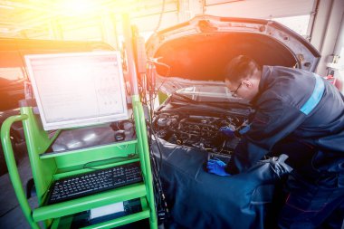 Otomatik onarım hizmetinde çalışan profesyonel araba tamircisi. Motor bilgisayar tanılama