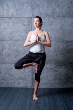 Gri duvar Yoga pratik kadın.