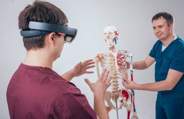 Doktor kullanır augmented gerçeklik gözlükleri ve öğrenci öğretim insan iskeleti