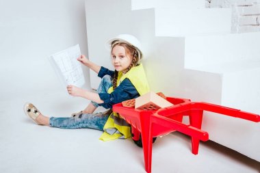 Onarım veya inşaat oynarken örgüler ile küçük neşeli kız