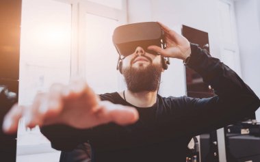 Sanal gerçeklik giyen sakallı genç adam ofiste gözlükler