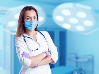 Ameliyathane içinde Orta Doğu görünümü ile genç kadın doktor.