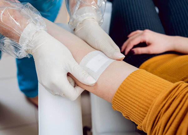 Closeup of nurse's hands taking a blood sample.