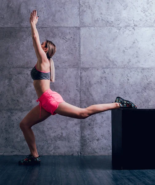 Studio poz ve farklı egzersizleri yapıyor genç atletik beyaz kadın.