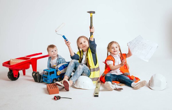 Little children playing in construction with tools