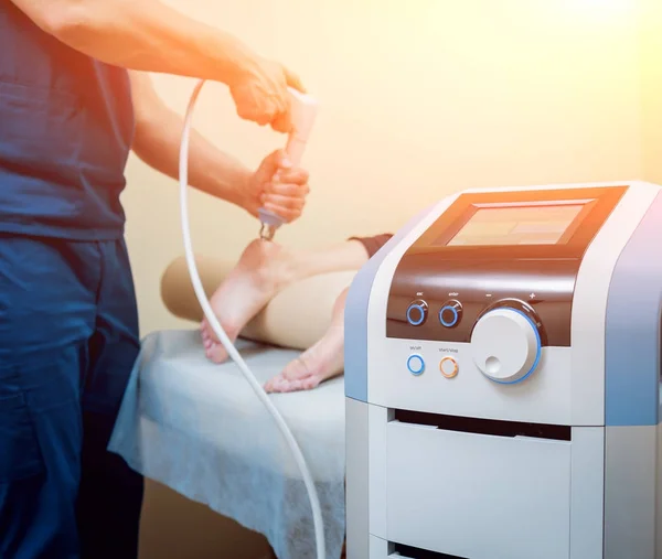 Shock wave therapy. The magnetic field, rehabilitation. Physiotherapist doctor performs surgery on a patient's heel — Stock Image Shock Wave Therapy Magnetic Field Rehabilitation Physiotherapist Doctor Performs Surgery Royalty Free Stock Images