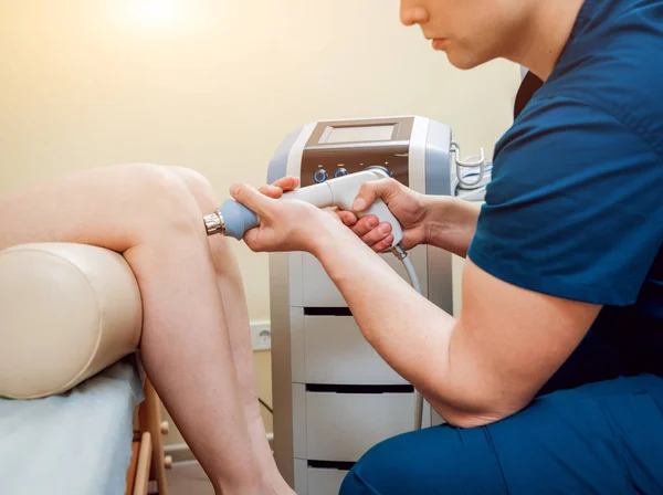 Shock wave therapy. The magnetic field, rehabilitation. Physiotherapist doctor performs surgery on a patient's knee — Stock Image Shock Wave Therapy Magnetic Field Rehabilitation Physiotherapist Doctor Performs Surgery Royalty Free Stock Images
