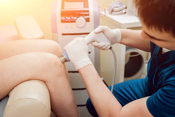 Shock wave therapy. The magnetic field, rehabilitation. Physiotherapist doctor performs surgery on a patient's knee — Stock Image Shock Wave Therapy Magnetic Field Rehabilitation Physiotherapist Doctor Performs Surgery Stock Photo