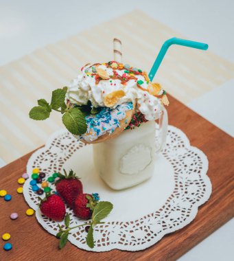 İle sprinkles, çilekli milkshake bardak çırpılmış krema ve taze çilek