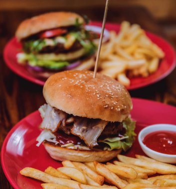 Büyük çizburger ve patates kızartması bir plaka üzerinde. Restoran