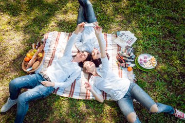 Üç genç kız enjoing piknik ve iş selfie Park.