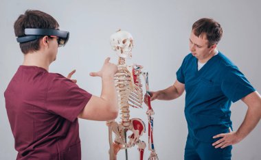 Doktor kullanır augmented gerçeklik gözlükleri ve öğrenci öğretim insan iskeleti