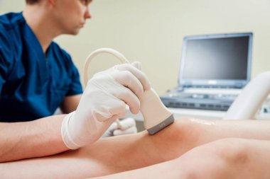 Ortopedi uzmanı doktor ofisinde hastayla. Diz ultrason.