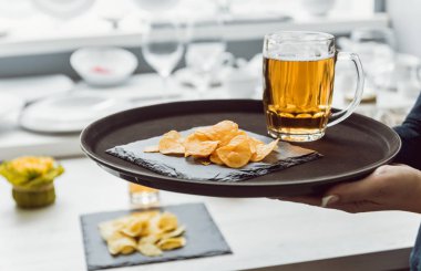 Bira ve cips büyük çanak üzerinde. Restoran