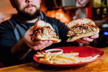 Man bir cheeseburger yemek. Restoran
