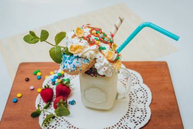 İle sprinkles, çilekli milkshake bardak çırpılmış krema ve taze çilek