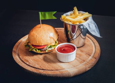Yangınlar ahşap tahta üzerinde büyük ve lezzetli burger.