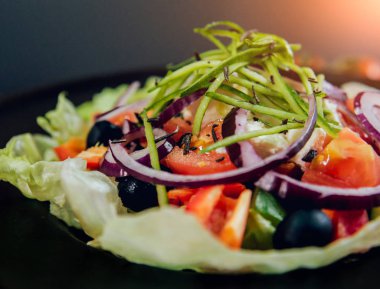 Lahana, zeytin ve mozzarella peyniri siyah plaka üzerinde Yunan salatası