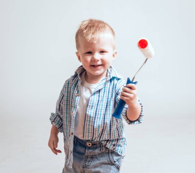 Silindir beyaz arka plan üzerinde olan küçük çocuk. İnşaat, onarım, İçişleri.