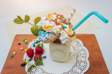 İle sprinkles, çilekli milkshake bardak çırpılmış krema ve taze çilek