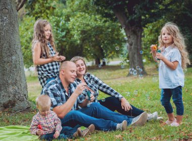 Büyük genç aile parkta iyi vakit geçiriyor.