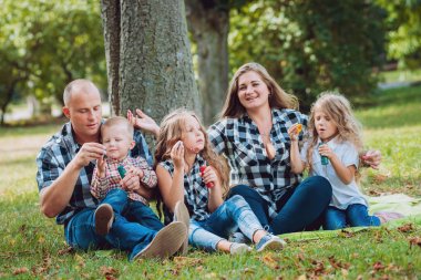 Büyük genç aile parkta iyi vakit geçiriyor.