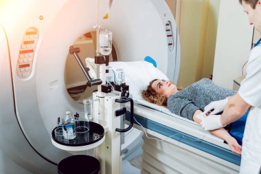 Tıbbi malzeme. Erkek beyaz doktor ve Bayan hasta hastanede bilgisayarlı tomografi odası.