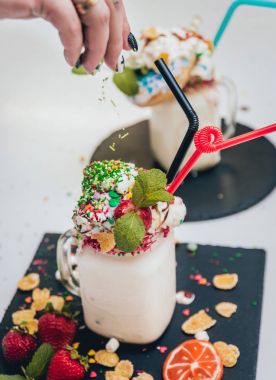 İle sprinkles, çilekli milkshake bardak çırpılmış krema ve taze çilek