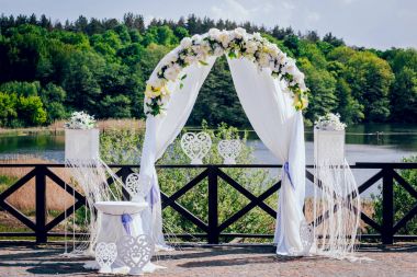 Beyaz ayağı ve ağaçlar ve nehir önünde çiçeklerle süslenmiş arch önden görünümü