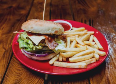 Büyük çizburger ve patates kızartması bir plaka üzerinde. Restoran