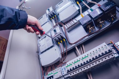 Elektrik kutusuna anahtarları test elektrikçiler eller. Sigortalar ve Kontaktörler elektrik paneli.