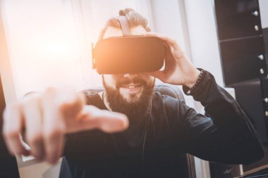 Sanal gerçeklik giyen sakallı genç adam ofiste gözlükler