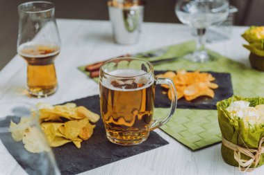 Bira ve büyük beyaz masanın üzerindeki fişlere. Restoran