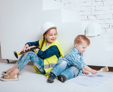 Örgüler ve onarım veya inşaat oynayan erkek kardeşi ile küçük kız